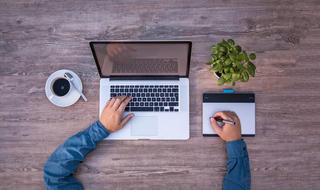Designer freelancer trabalhando com tablet grafico e macbook em home office profissional criativo
