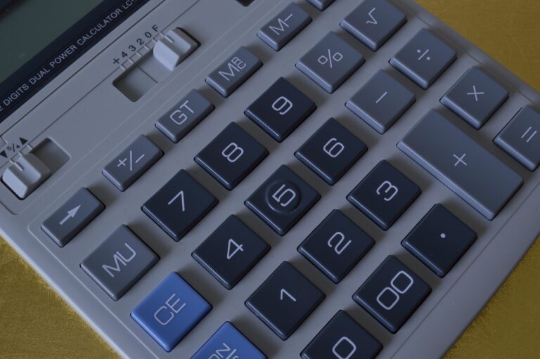 Contador freelancer trabalhando com calculadora e planilhas financeiras no escritório