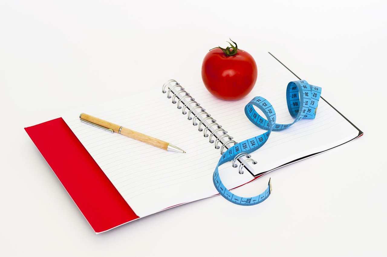 Fita métrica e anotações usadas no acompanhamento de resultados com nutricionista online