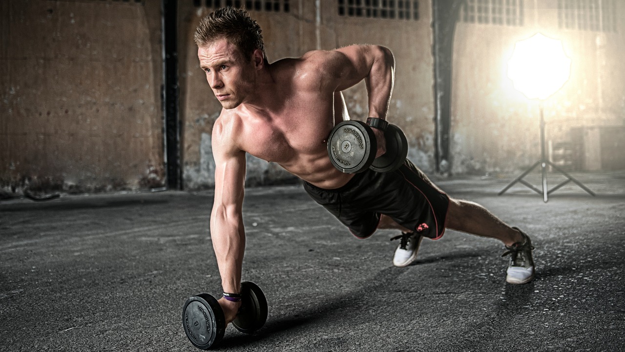Homem treinando musculação com halteres seguindo plano de personal trainer online